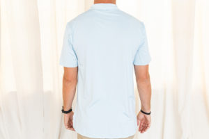 Back view of male model wearing pale blue polo